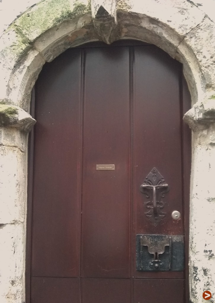 Door in a 16th century stone arch, and with a lock that has two metal strips leading to a keyhole